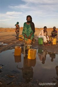 Local women collect water at a water well outside Akokan village. A Greenpeace team is visiting the area searching for dangerous levels of radiation in the cities located close to two uranium mines owned by French company AREVA.